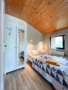 una camera con letto e soffitto in legno di Domki u Projektantek a Władysławowo