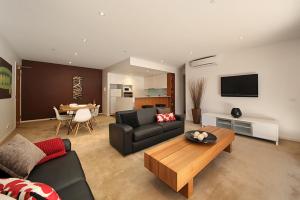 a living room with a couch and a table at Brighton Bay Apartments in Melbourne
