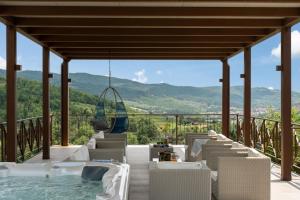 una terraza con bañera de hidromasaje, sillas y vistas. en Villa Castelluccio, 