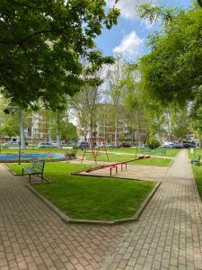einen Park mit einem Spielplatz mit Bänken und Bäumen in der Unterkunft Risteski Inn in Prilep
