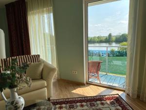 a living room with a couch and a large sliding glass door at Senjorų Eldoradas apartments in Žemaičių Naumiestis