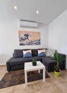 a living room with a black couch and a table at Apartment Rivarela BLU - newly renovated and top location near sea in Novigrad Istria