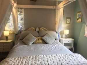 Una cama con sábanas blancas y almohadas en un dormitorio en Gîte Le Dolmen, Cognac, en Julienne