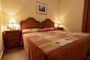 1 dormitorio con 1 cama grande y 2 mesitas de noche en Pensio La Creu, en Esterri d'Àneu
