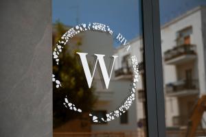 d'une fenêtre avec un panneau de signalisation sur une porte en verre dans l'établissement White Coast, à Polignano a Mare