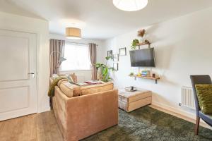 a living room with a couch and a tv at Host & Stay - Cornflower Way in Lassington