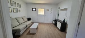 uma sala de estar com um sofá e uma mesa em Apartamento en casa rural B2 en entorno natural em Navas del Rey