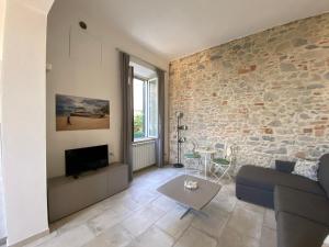 a living room with a couch and a stone wall at Villa Rosy in San Vincenzo