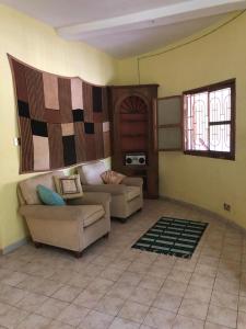 een woonkamer met een bank en een tafel bij Karamba Lodge in Kafountine