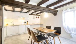 a kitchen and dining room with a table and chairs at La Champenoise in Troyes