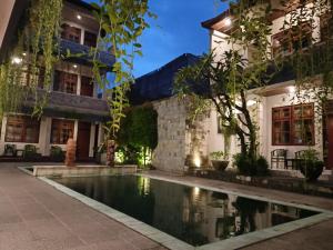 a house with a swimming pool in front of a building at Catur Adi Putra in Denpasar