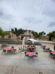 een groep tafels en stoelen met parasols bij LA SOCIEDAD in Arens de Lledó