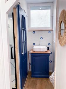 uma casa de banho com um lavatório azul e uma janela em Studio Tehani em Quiberon