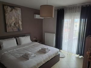 1 dormitorio con 1 cama grande y toallas. en Homing Volos Exclusive Luxury Residence, en Volos