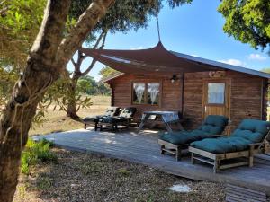 a wooden cabin with chairs and a table on a deck at Chalet Climatisé SANTA MARIA à Bonifacio in Bonifacio