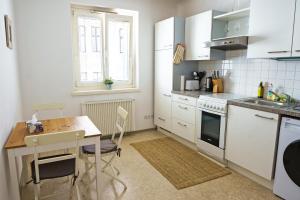 een keuken met witte apparatuur en een tafel met stoelen bij Vienna Living Apartments - Mühlfeldgasse in Wenen