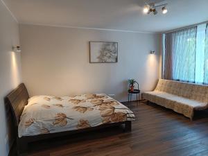 a bedroom with a bed and a window and a couch at NarvaCenter 2, рядом с границей in Narva