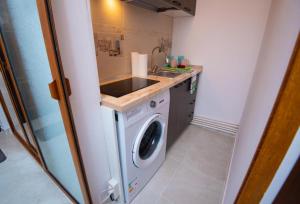 Una pequeña cocina con fregadero y lavadora. en Studio zona Țiglina Flori, en Galaţi 2 fotos más