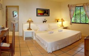 錫帕萊的住宿－易潛海灘度假村，卧室配有一张白色大床