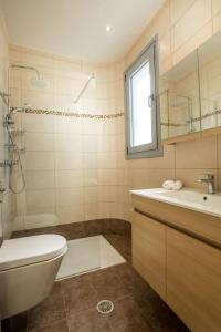 bagno con servizi igienici, lavandino e specchio di Melilia luxury villa a Gennadi