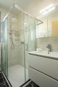 bagno con doccia in vetro e lavandino di Melilia luxury villa a Gennadi