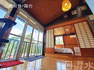 a room with large windows and a bed in it at 日月潭馨蓮鄉居x洄澀水包棟民宿 in Yuchi