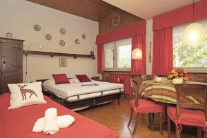a bedroom with two beds and a table and chairs at iFlat Apartment Madonna di Campiglio Casa di Betti in Madonna di Campiglio