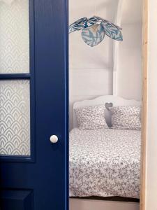 a blue door in a room with a bed at Studio Tehani in Quiberon