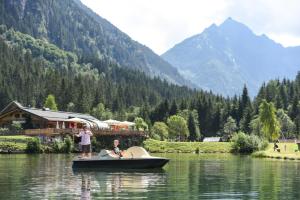 a man and a woman standing on a boat in the water at Haus Silent Apartment TOBI TOP 27 in Schladming