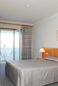 a bedroom with a bed with a view of the ocean at Up Pateira Hotel in Fermentelos
