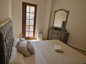 - une chambre avec un lit avec un miroir et une télévision dans l'établissement Port Saplaya 3 Valencia, à Port Saplaya