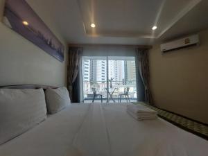 a bedroom with a large white bed with a balcony at V Check inn Sukhumvit 22 in Bangkok