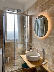 ein Bad mit einem Waschbecken und einer Dusche mit einem Spiegel in der Unterkunft Cinéma privé/ Proche Paris/Orly in Athis-Mons