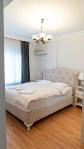 a bedroom with a large bed with a chandelier at Spacious Villa with Sea and Mountain View in Kemer