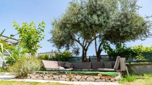 a couch sitting under a tree in a yard at Spacious Villa with Sea and Mountain View in Kemer