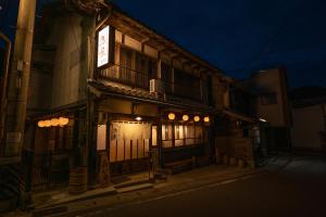 un edificio con un cartello sul lato di esso di notte di 飛騨金山 古民家宿 恩家 -おんや- a Gero