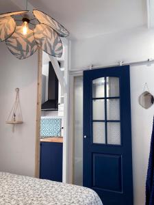 a bedroom with a blue door and a bed at Studio Tehani in Quiberon