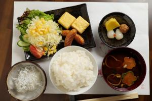 un gruppo di ciotole di riso e verdure di 飛騨金山 古民家宿 恩家 -おんや- a Gero