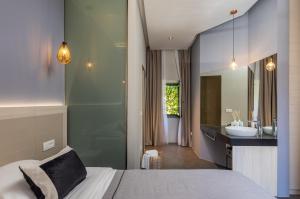 a bedroom with a bed and a bathroom with a sink at Apartments and Rooms Lejletul in Dubrovnik