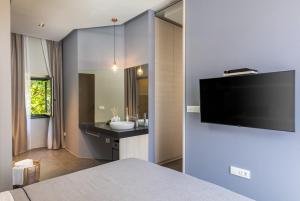 a bedroom with a tv on a wall next to a bathroom at Apartments and Rooms Lejletul in Dubrovnik