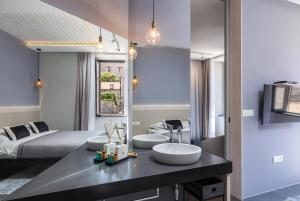 a bathroom with three sinks and a bed at Apartments and Rooms Lejletul in Dubrovnik
