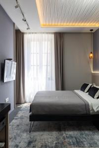 a bedroom with a large bed and a television at Apartments and Rooms Lejletul in Dubrovnik