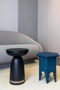 a black table and a blue stool in front of a couch at Apartments and Rooms Lejletul in Dubrovnik