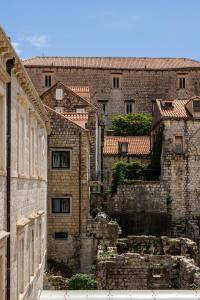 an old stone building with stairs in front of it at Apartments and Rooms Lejletul in Dubrovnik