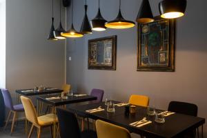 a dining room with tables and chairs and lights at Apartments and Rooms Lejletul in Dubrovnik