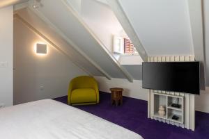 a bedroom with a bed and a tv and a chair at Apartments and Rooms Lejletul in Dubrovnik