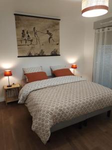 a bedroom with a bed and a painting on the wall at Appartement neuf classé, balcon et petite vue mer in Pléneuf-Val-André