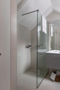 a glass shower in a bathroom with a sink at Apartments and Rooms Lejletul in Dubrovnik
