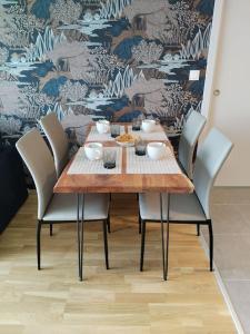 uma mesa de jantar com cadeiras e uma parede em Appartement neuf classé, balcon et petite vue mer em Pléneuf-Val-André