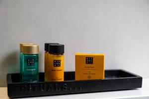 a shelf with three bottles of hair products on it at Apartments and Rooms Lejletul in Dubrovnik